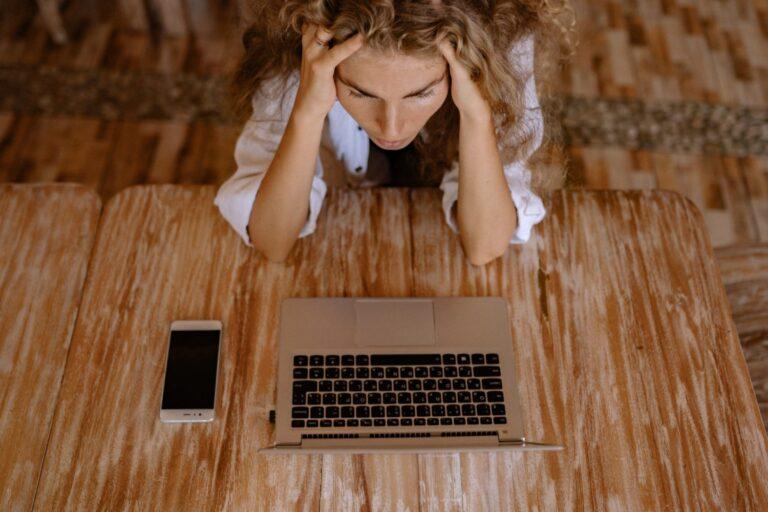 a woman sitting at a table with a laptop