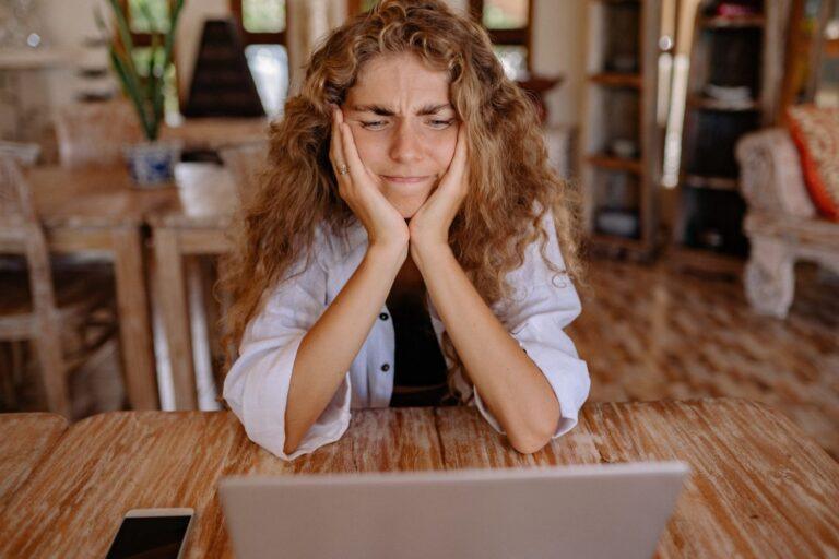 a woman sitting in front of a laptop computer