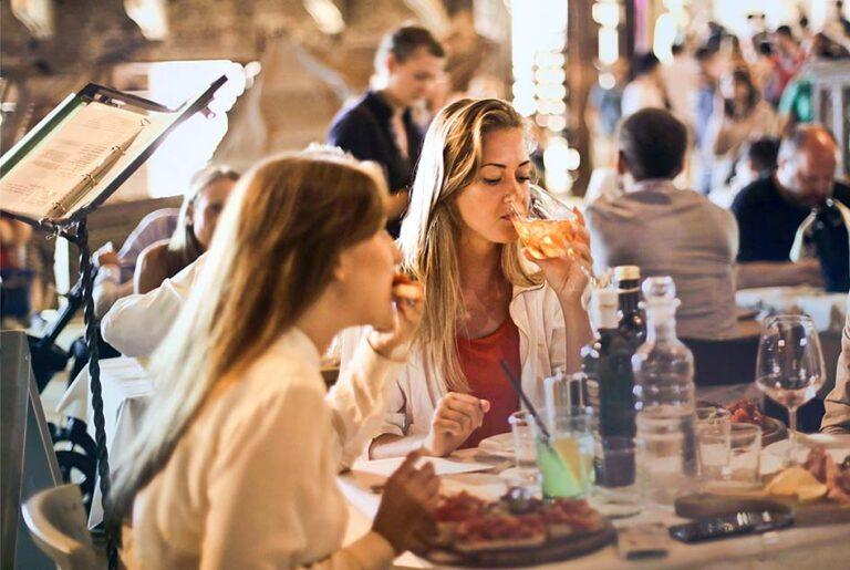 three women sitting at a table eating food