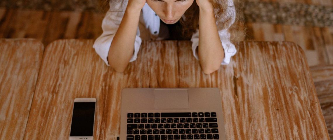 a woman sitting at a table with a laptop