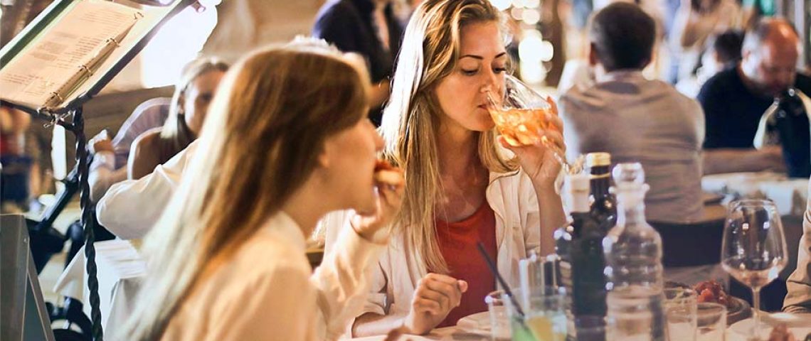 three women sitting at a table eating food