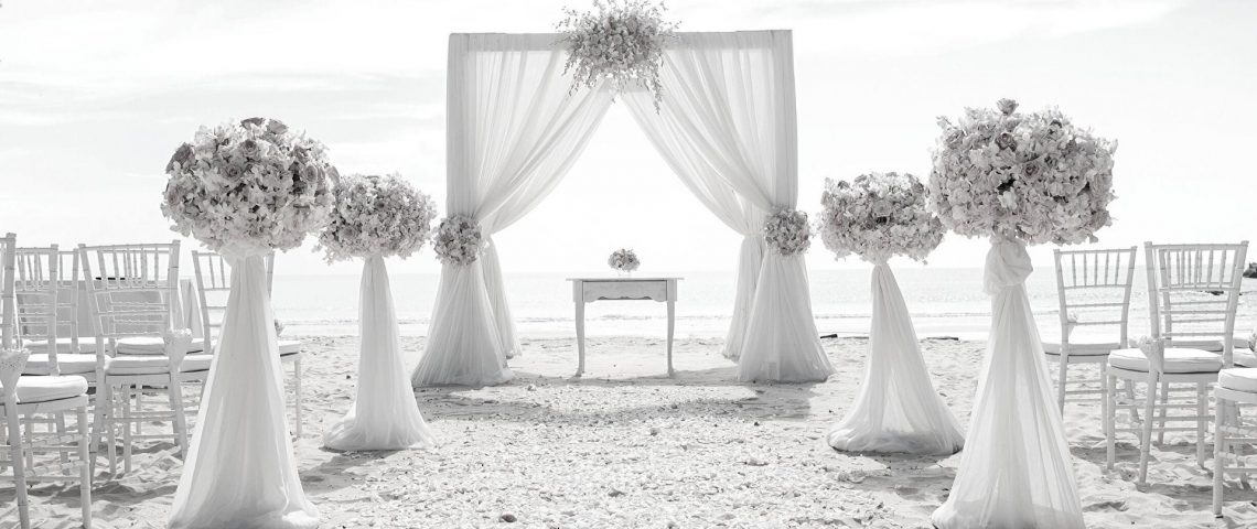 an outdoor ceremony setup with white drapes and flowers