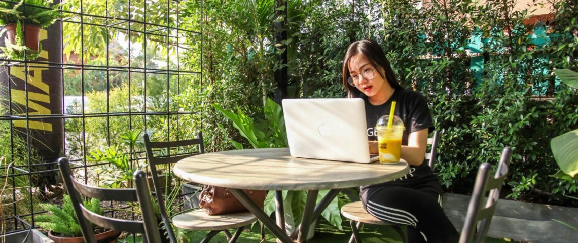 a woman sitting at a table with a laptop