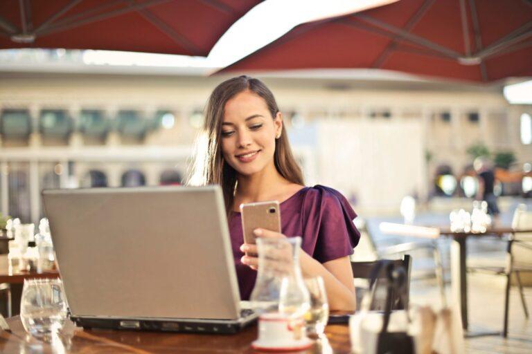 a woman sitting at a table using a laptop computer